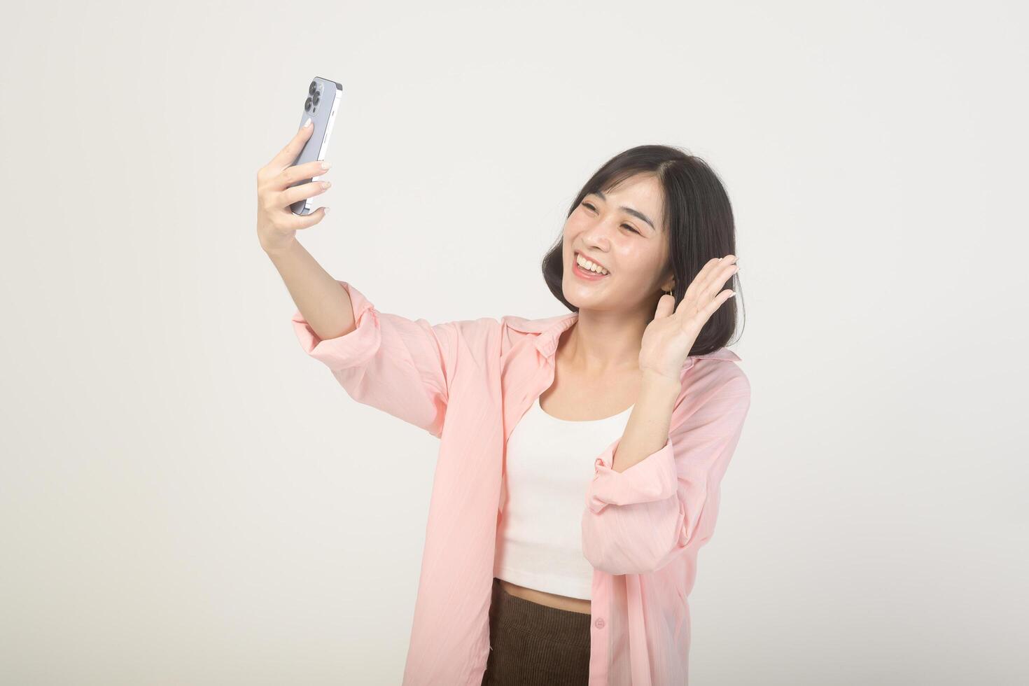 joven asiático mujer utilizando teléfono inteligente terminado blanco fondo, tecnología concepto foto