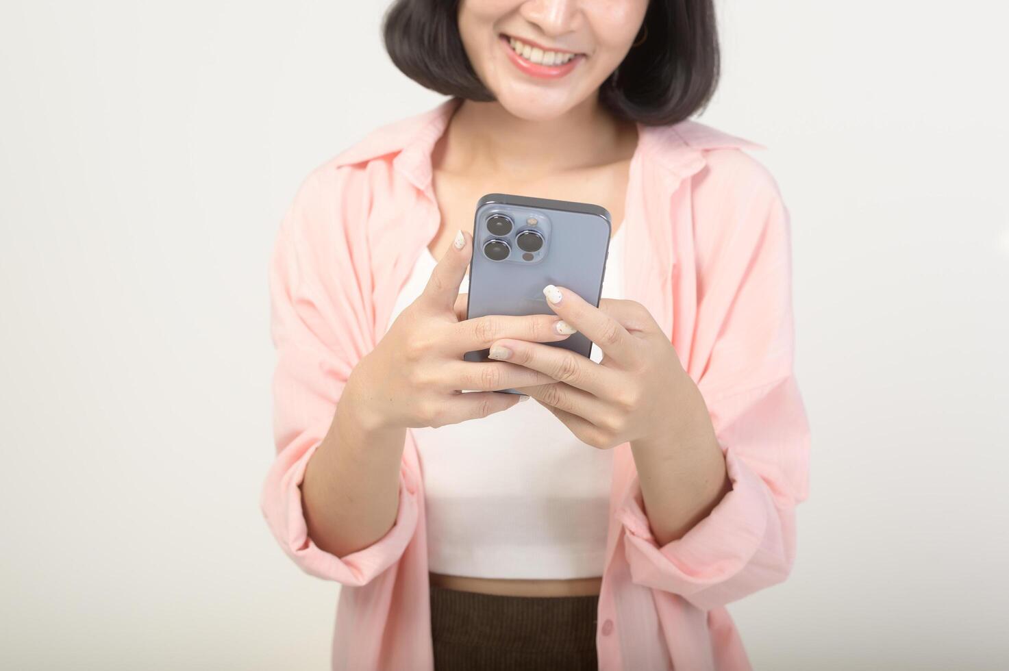 Young asian woman using smartphone over white background, technology concept photo