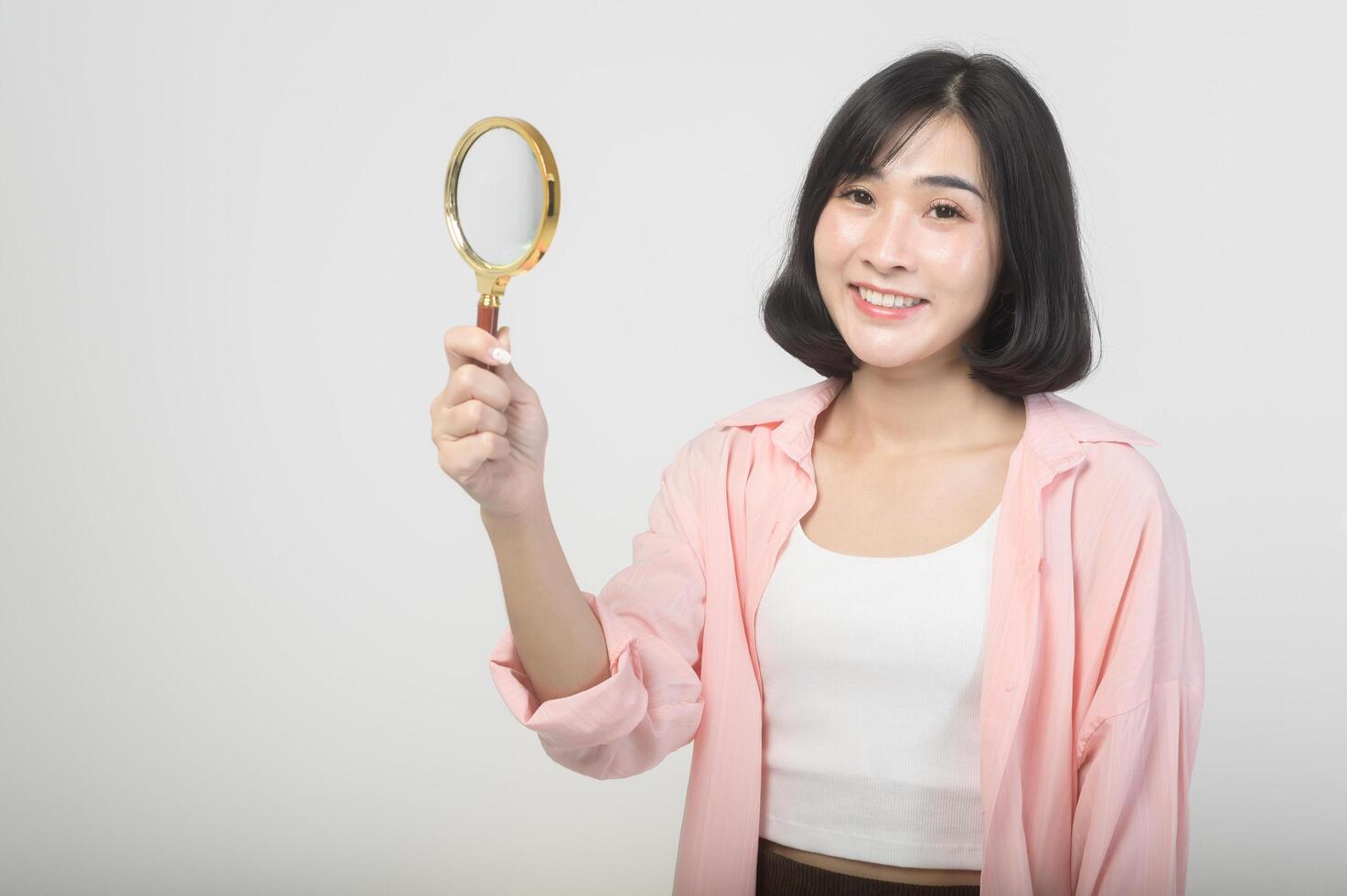 joven asiático mujer participación aumentador vaso terminado blanco fondo, análisis y Finanzas concepto foto