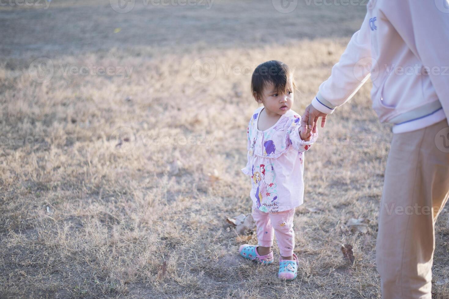 Mother and daughter playing and running around the park on beautiful morning. photo