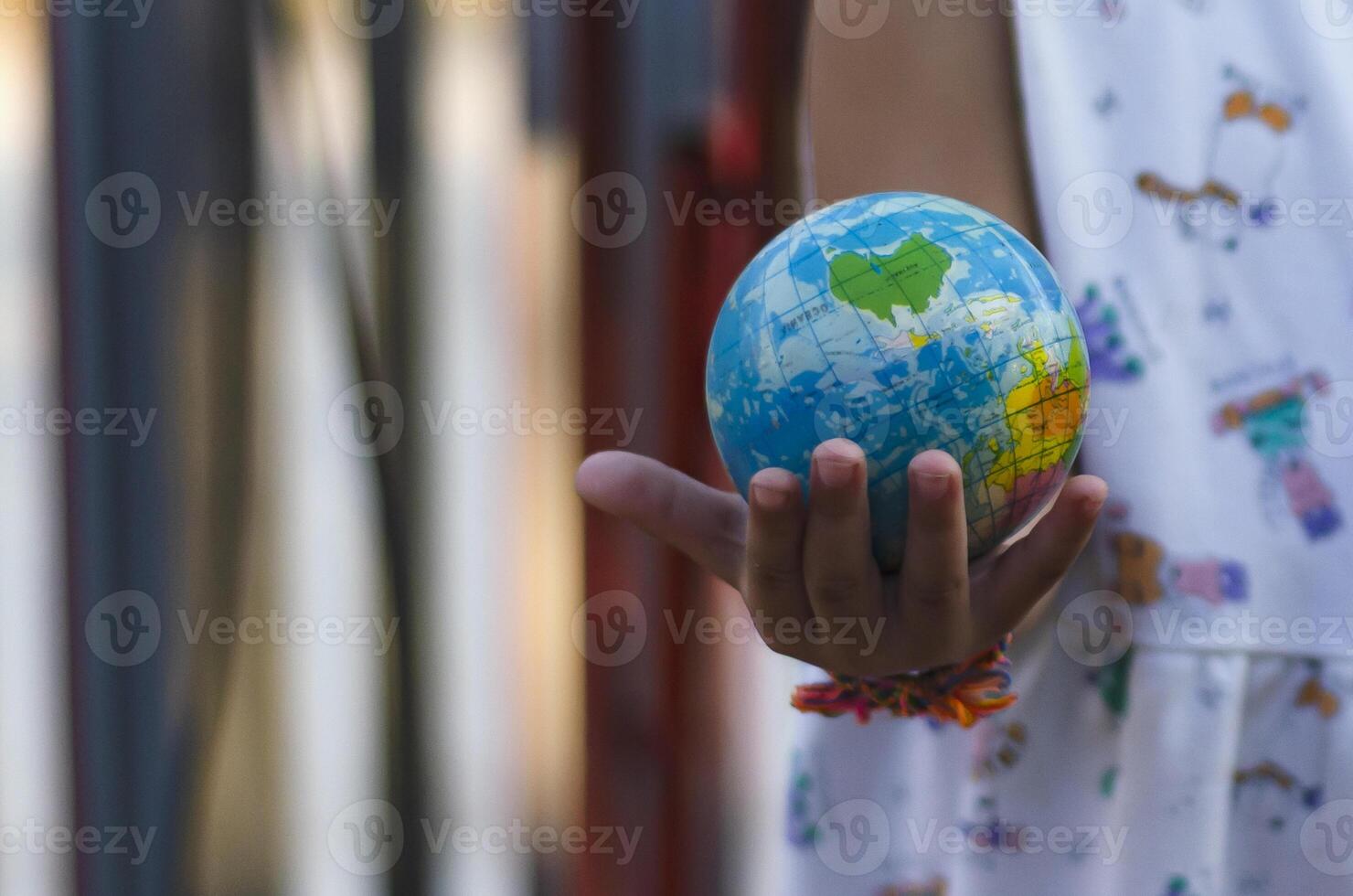 Girl's hands with a globe with a background of solar panels Concept of saving the world with renewable energy. photo