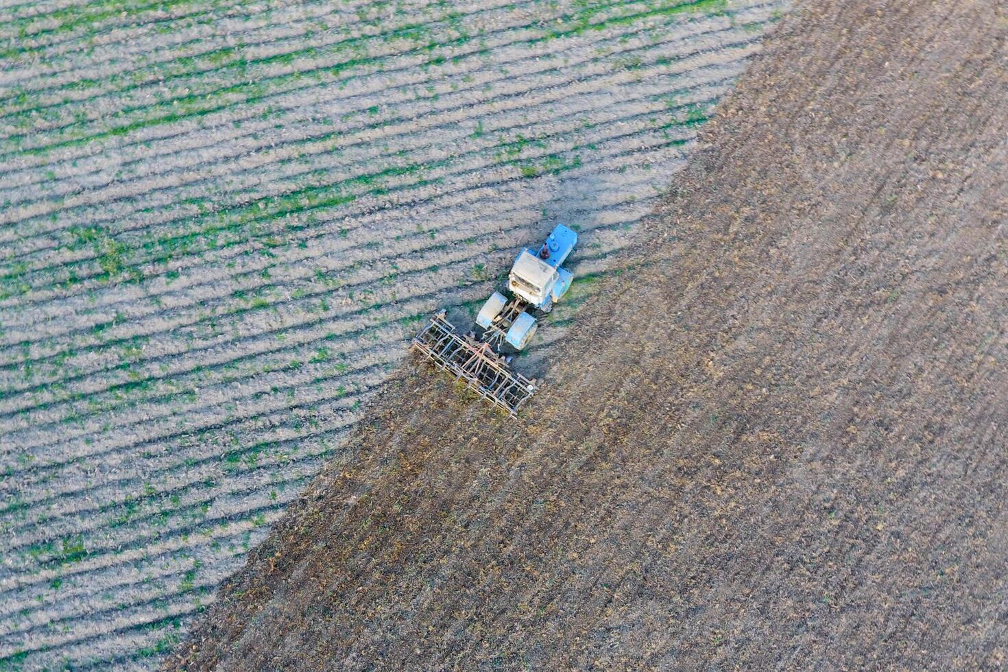 Top view of the tractor that plows the field. disking the soil. Soil cultivation after harvest photo
