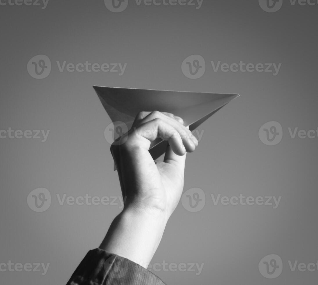 White paper airplane in hand against the sky. A symbol of freedom on the Internet photo