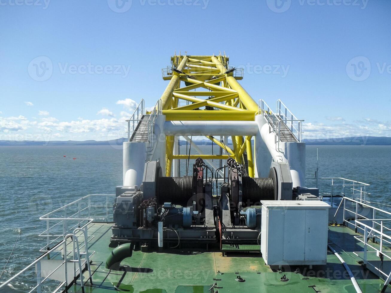 Laying of pipes with pipe-laying barge crane near the shore. Descent of the pipeline to a bottom exhausting with the pipelaying barge. Installation of the underwater gas pipeline photo