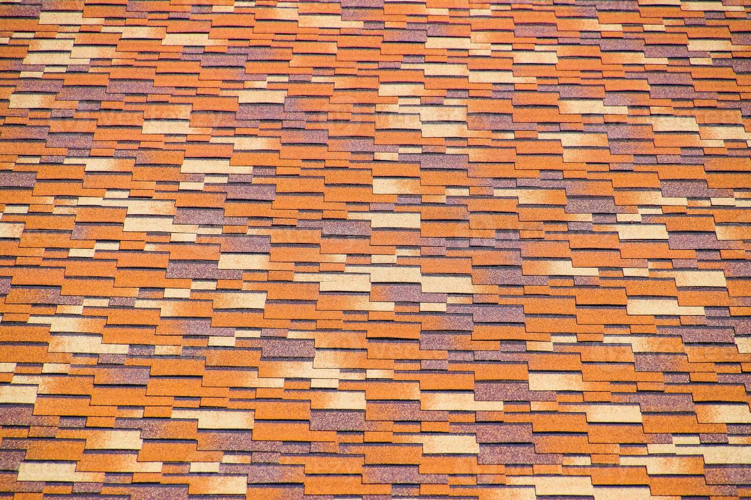 Roof from multi-colored bituminous shingles. Patterned bitumen shingles. photo