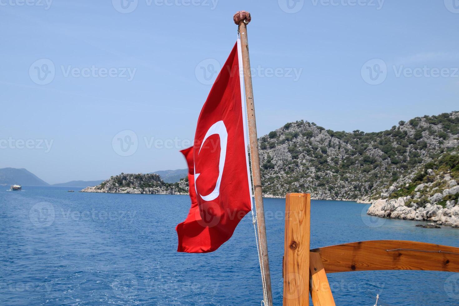 Turkey flag at the stern of a pleasure yacht. View of Mediterranean coast photo