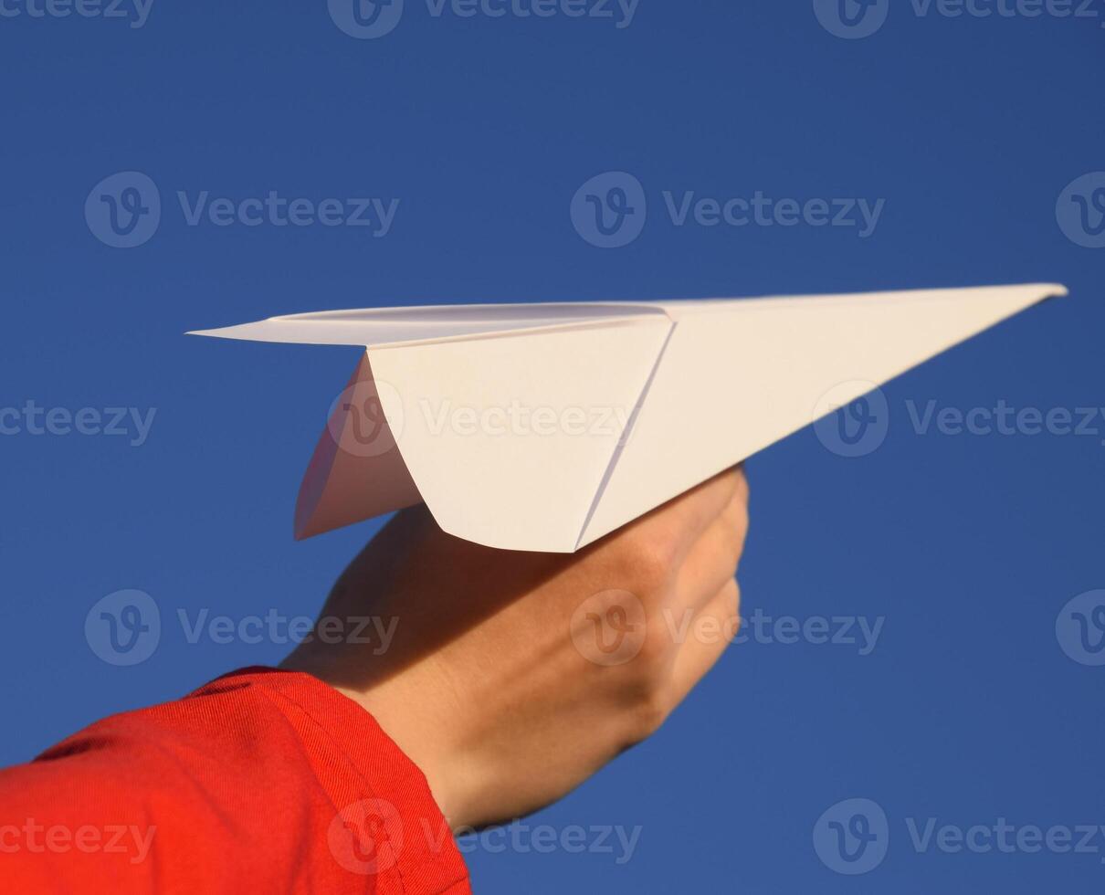 White paper airplane in hand against the sky. A symbol of freedom on the Internet photo