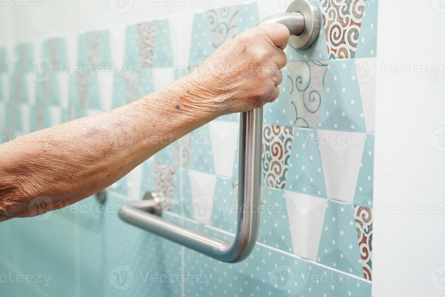 Asian elderly old woman patient use toilet support rail in bathroom, handrail safety grab bar, security in nursing hospital. photo