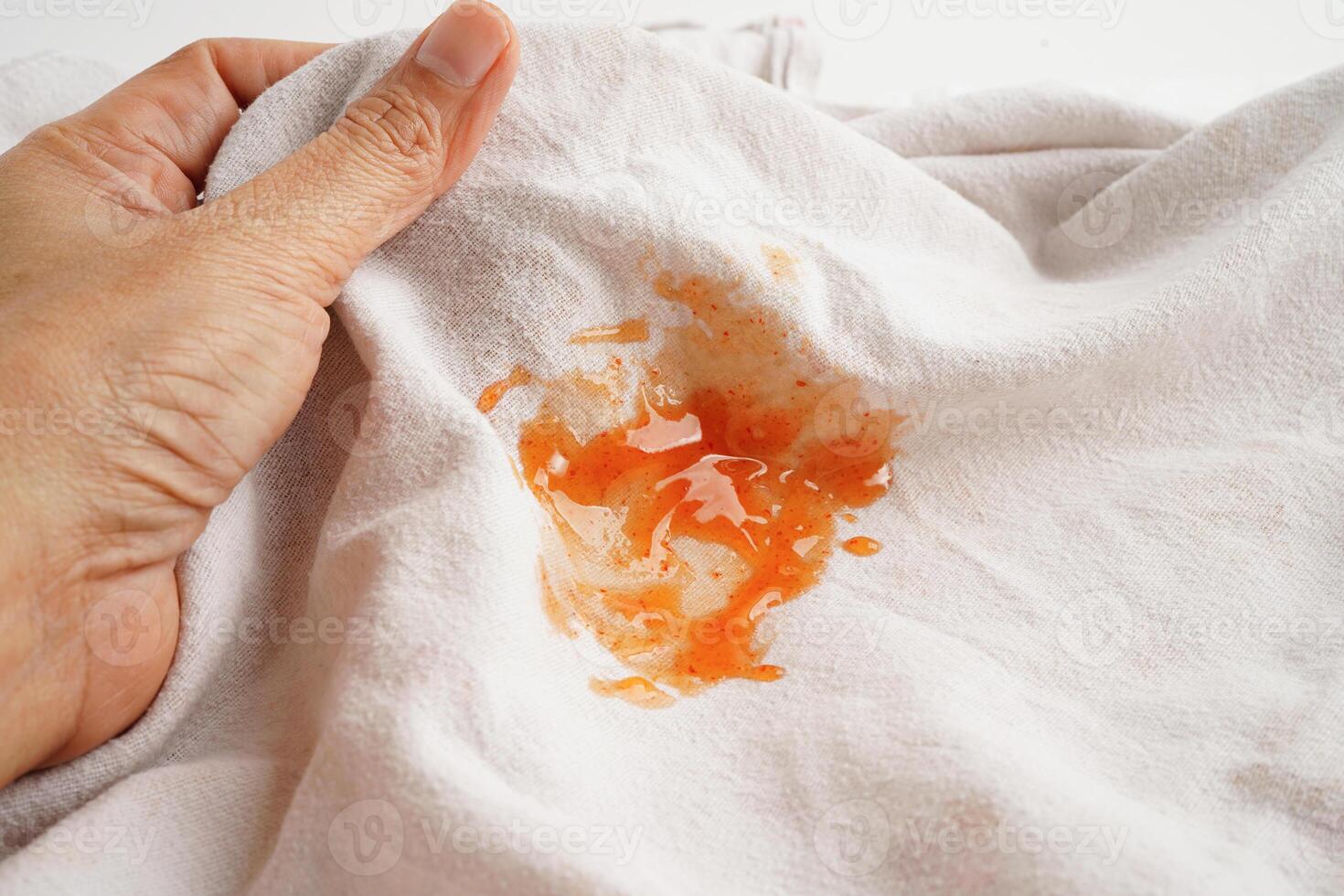 mancha de salsa picante sucia en la tela para lavar con detergente en polvo, limpieza del concepto de tareas domésticas. foto