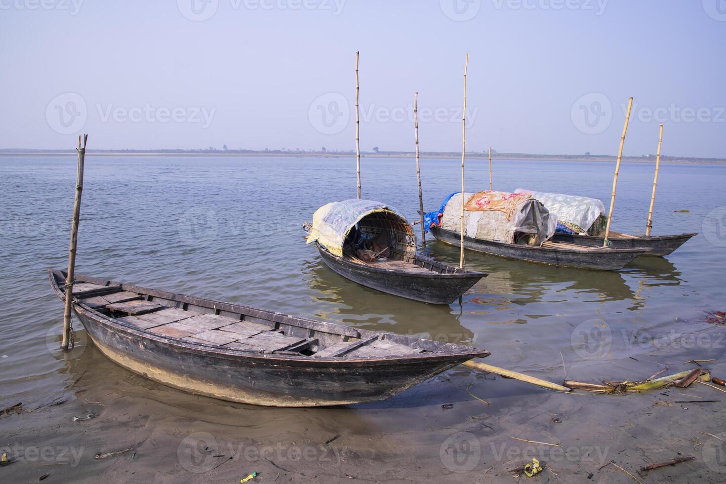 landscape view of Some wooden fishing boats on the shore of the Padma river in Bangladesh photo