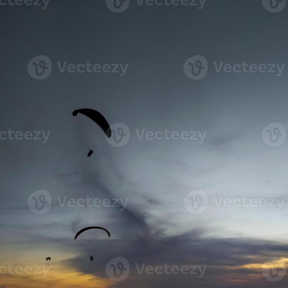 silueta de un parapente altísimo en el tarde cielo. extremo Deportes. foto