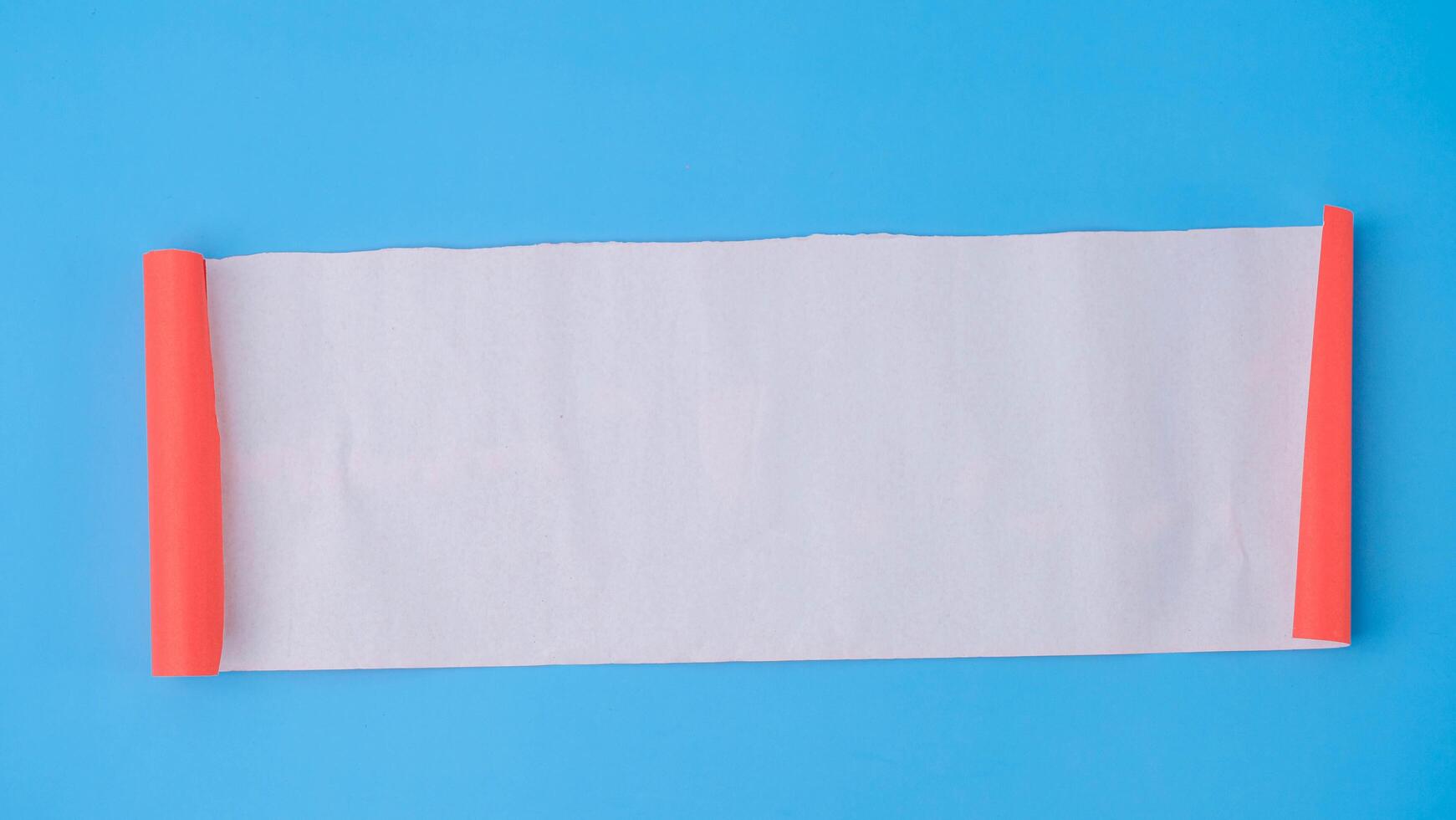 An orange rolled square paper is spread out into a blank white sheet on a light blue background. Crumpled blank white paper with copy space for text or advertising space. photo