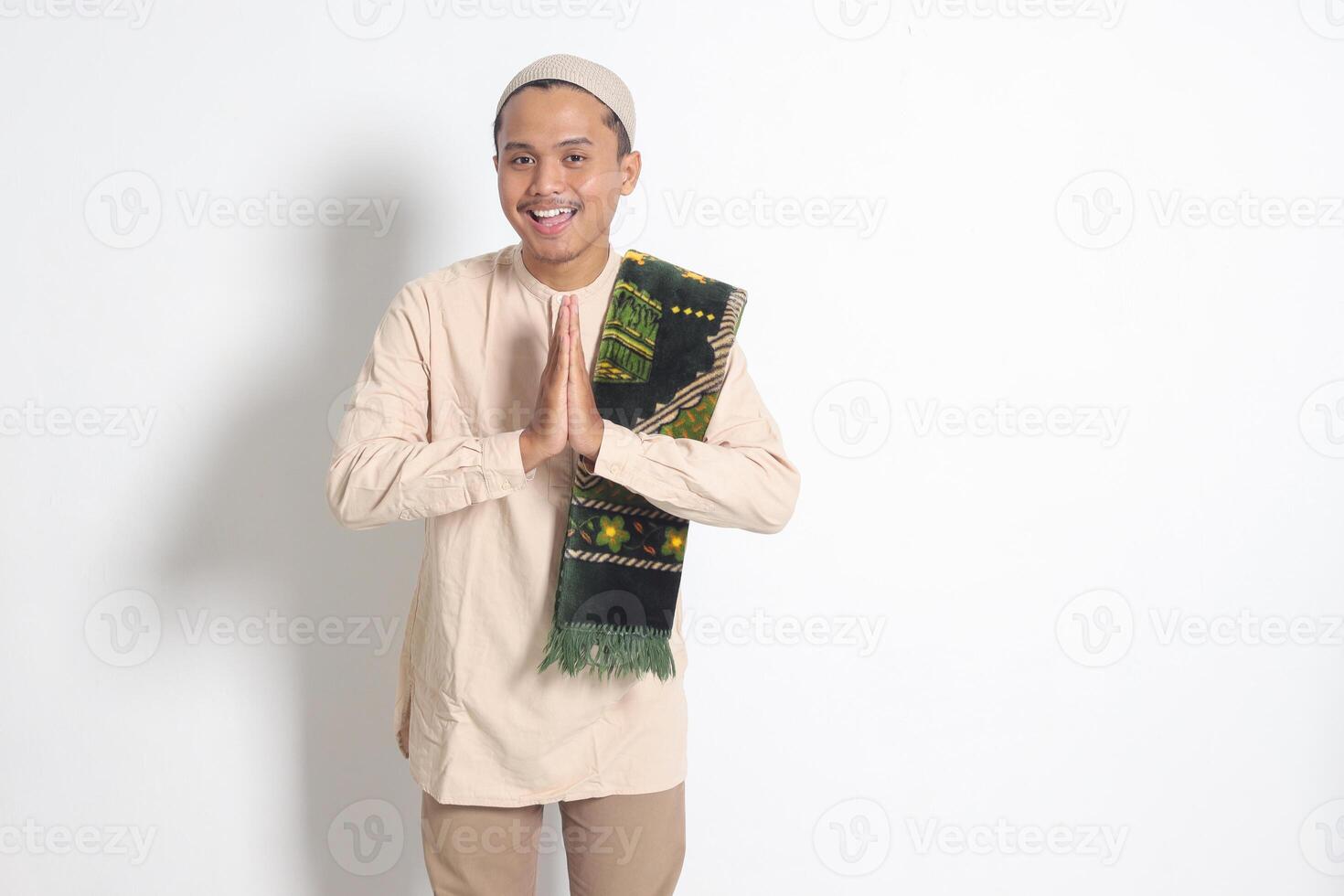 retrato de atractivo asiático musulmán hombre en koko camisa con oración estera demostración pedir disculpas y Bienvenido mano gesto. disculpa durante eid mubarak. aislado imagen en blanco antecedentes foto