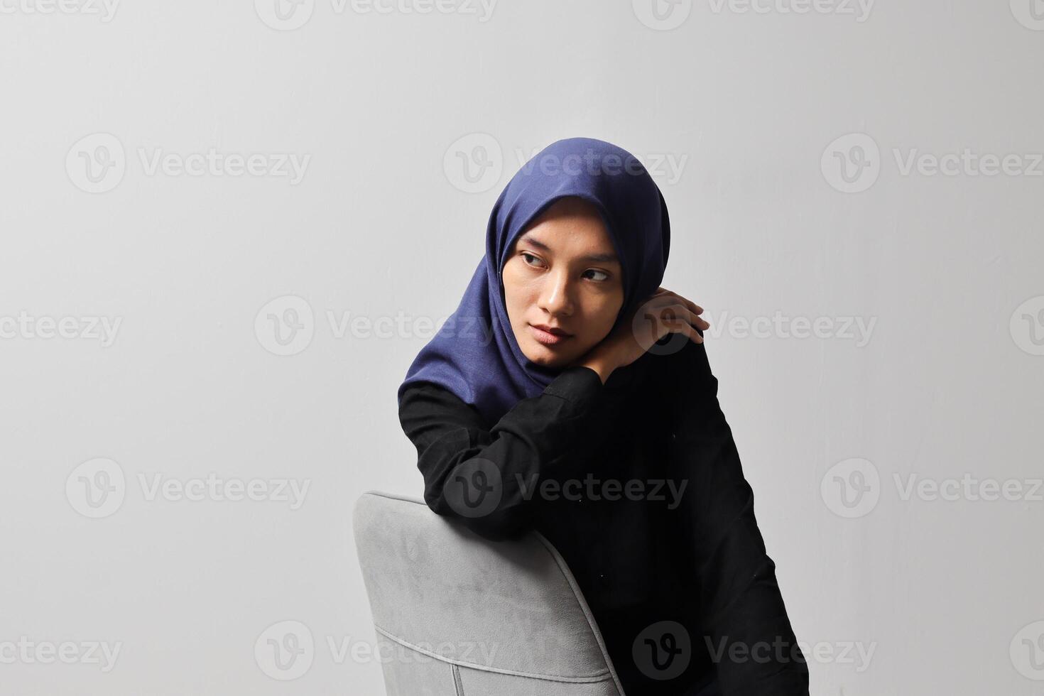 grave asiático hijab mujer en casual camisa sentado en silla, posando con varios mano gesto. aislado estudio retrato en gris antecedentes. foto