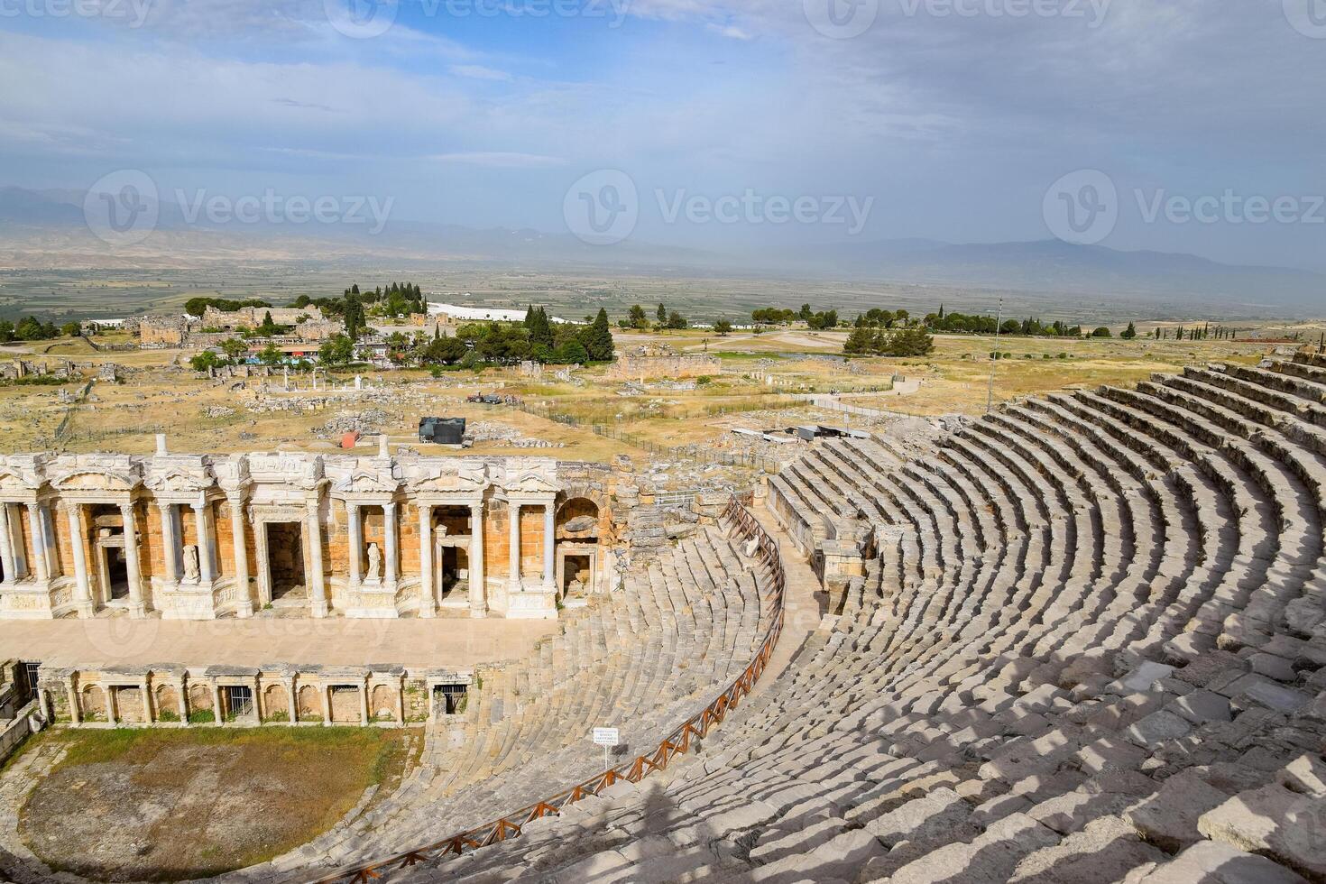 Ancient antique amphitheater in city of Hierapolis in Turkey. Steps and antique statues with columns in the amphitheater photo