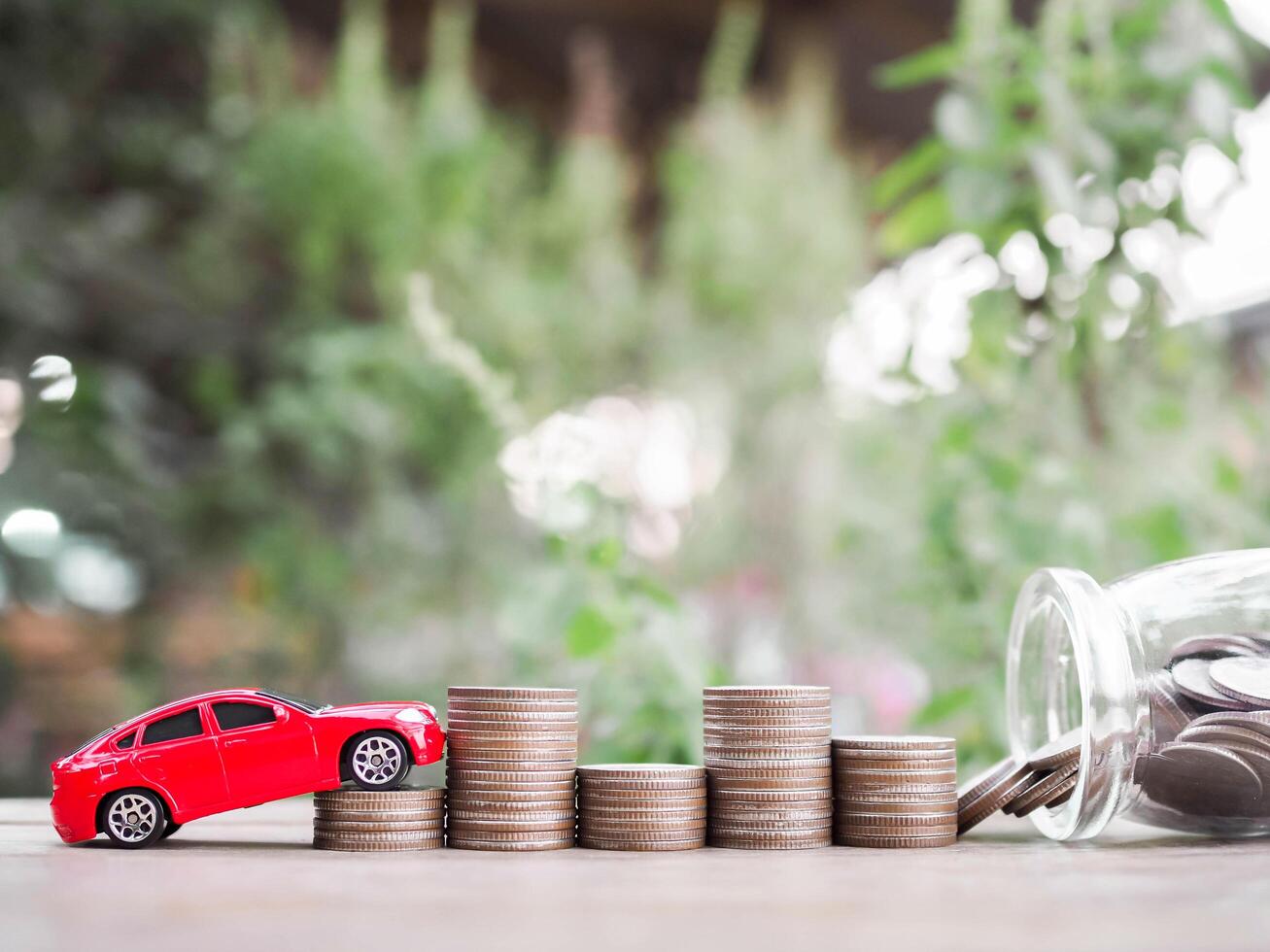 juguete carros en apilar de monedas el concepto de ahorro dinero y gestionar a éxito transporte negocio foto