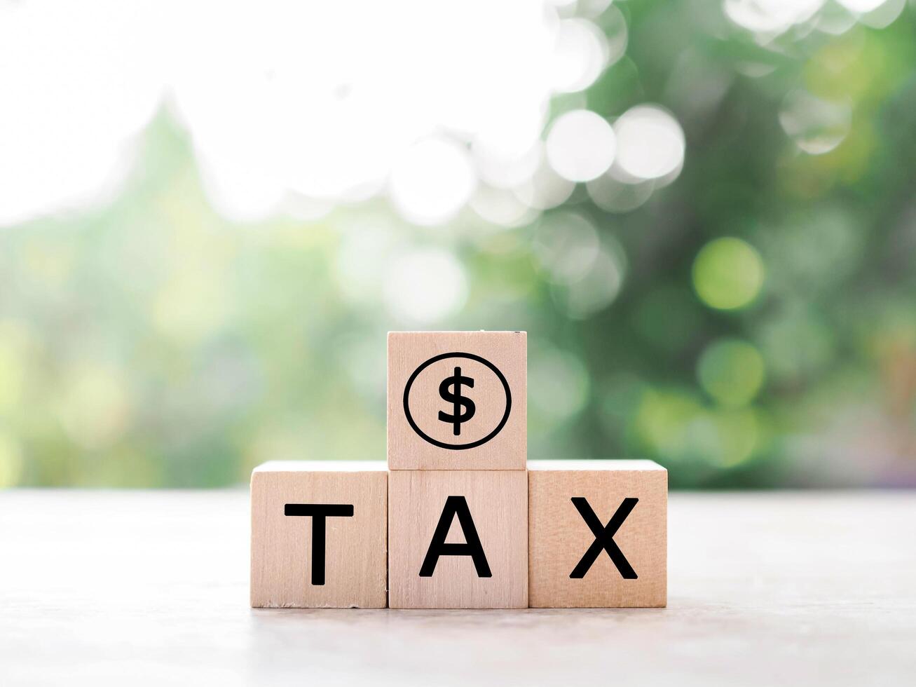 Wooden blocks with the word TAX and Dollar coin icon. The concept of prepare to pay tax. photo