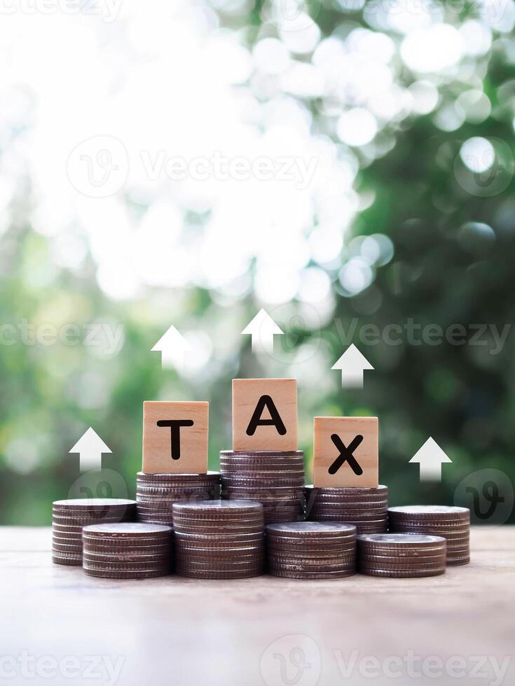 Wooden blocks with the word TAX on stack of coins. The concept about saving money and manage time to paying tax photo