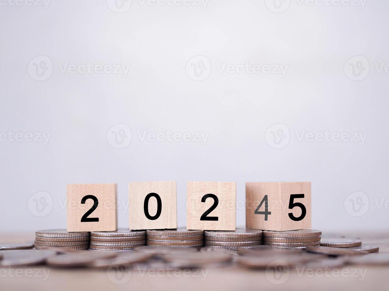 Flipping of 2024 to 2025 on wooden blocks on stack of coins. The concept of saving money for business achievement goal, Financial, Investment and Business growing in new year 2025. photo