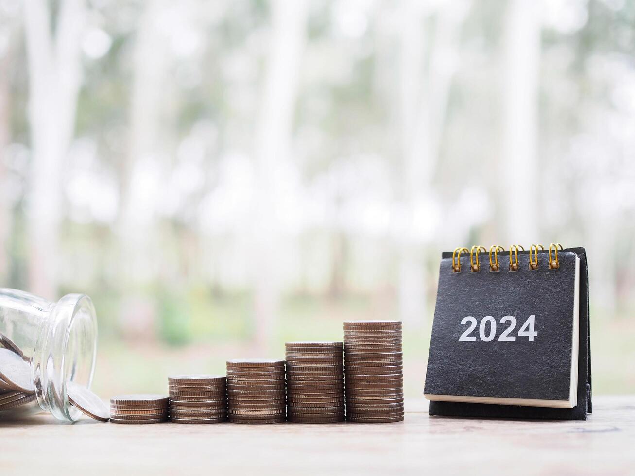 2024 escritorio calendario y apilar de monedas el concepto de negocio crecimiento, financiero inversión, mercado existencias, lucro devolver, dividendo y negocio fondo en año 2024 foto