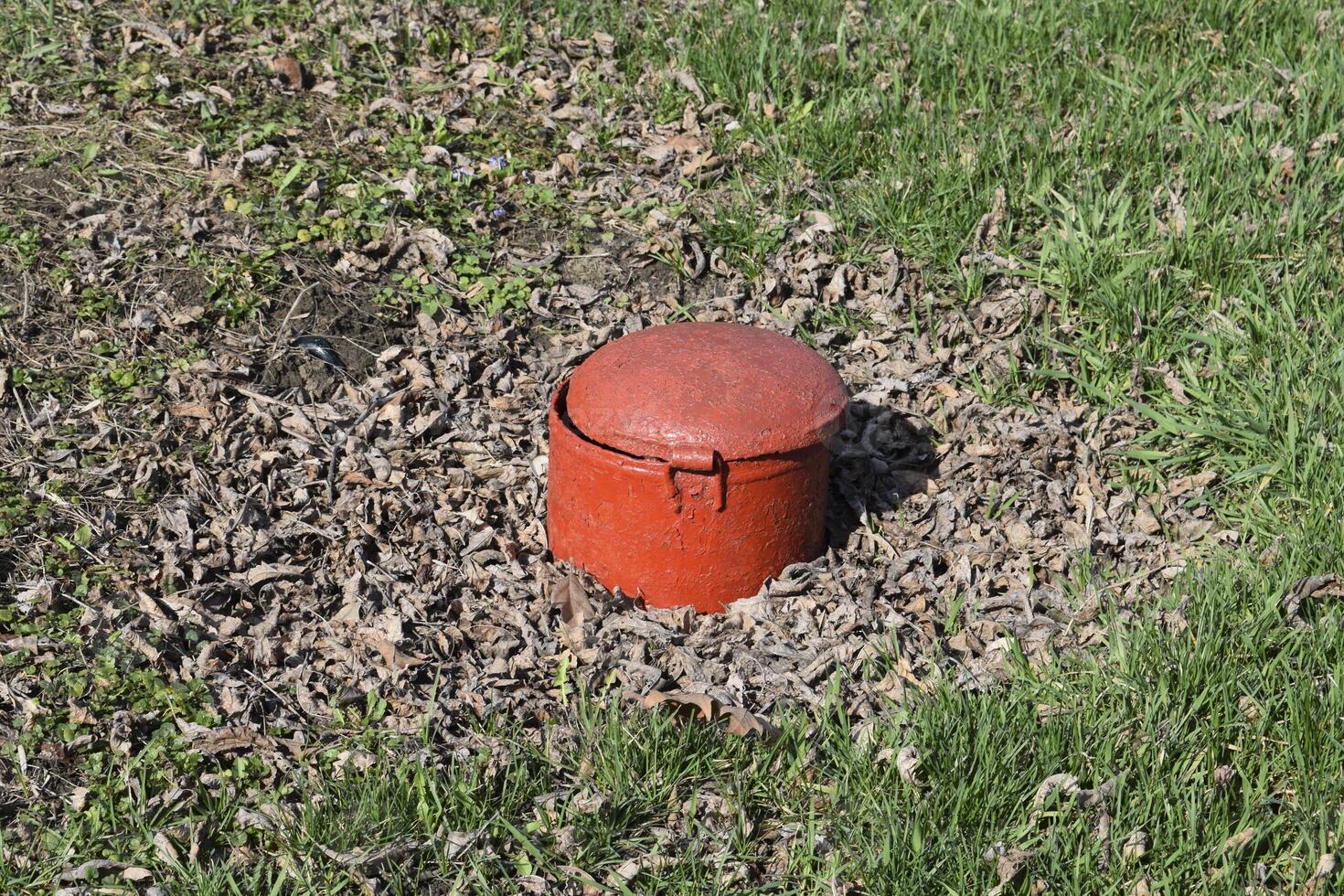 hatch steel, red color. in park there is a sewerage. photo