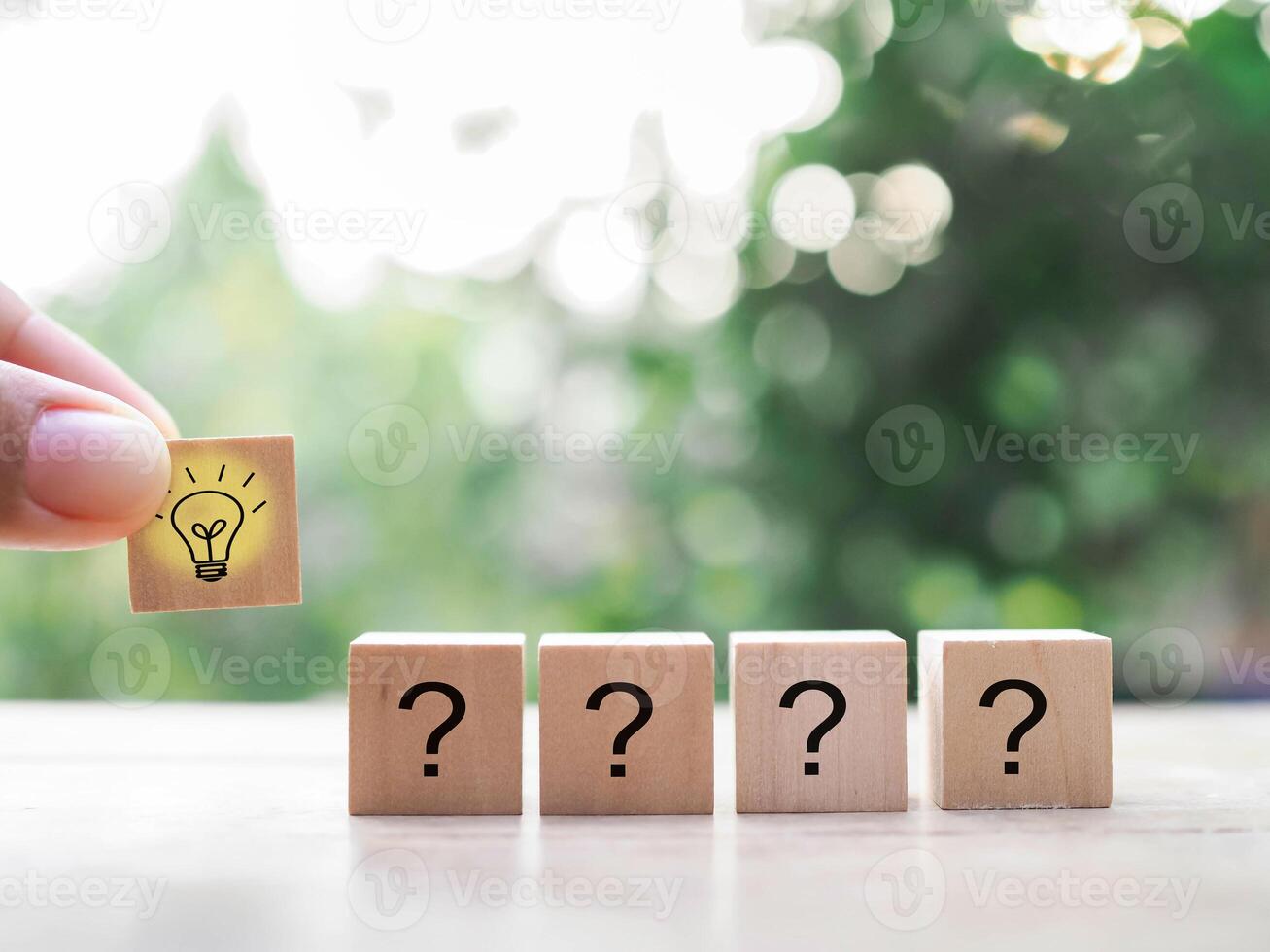 Close up hand arranging wooden block with light bulb and wooden block with question mark for leadership, creative, idea, innovation concept. photo