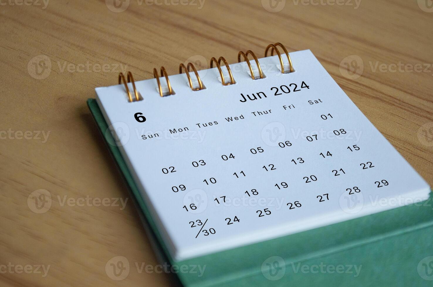 Close up side view of June 2024 calendar on wooden desk. Calendar concept photo