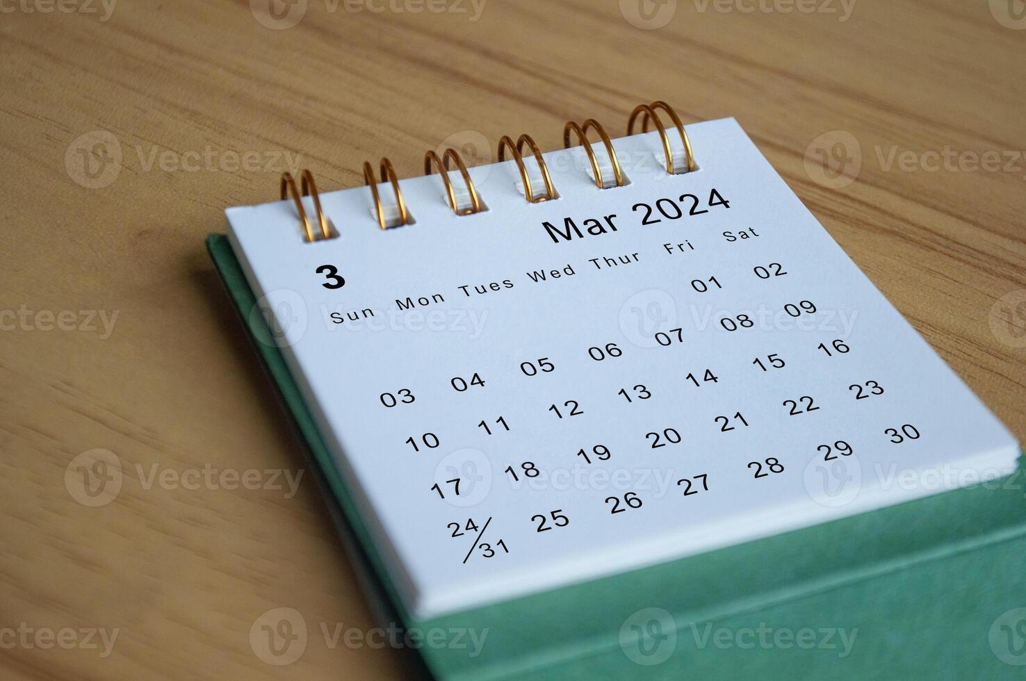 Close up side view of March 2024 calendar on wooden desk. Calendar concept photo