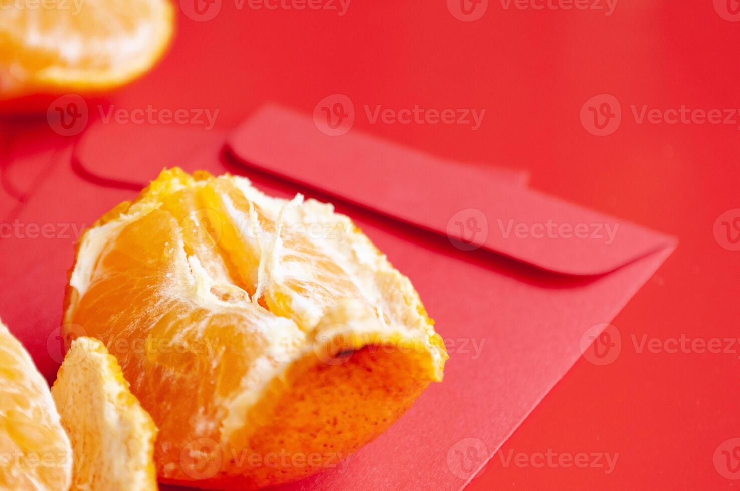 Peal Mandarin oranges on top of Chinese New Year red packet. Chinese New Year celebration concept photo