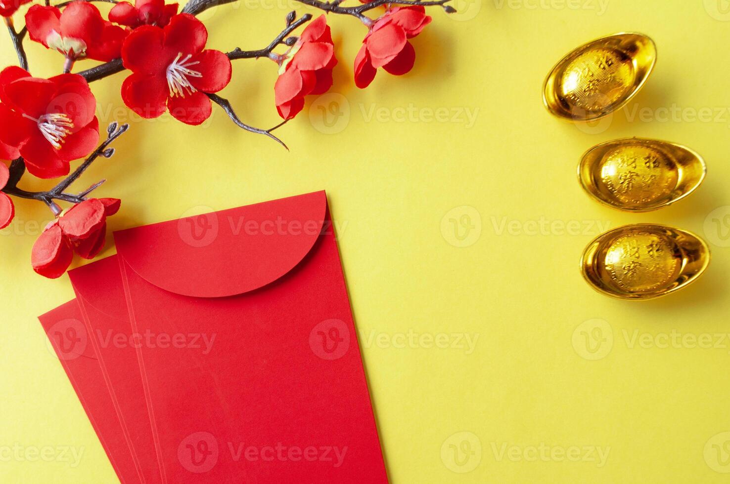 Top view of Chinese New Year red packet, cherry blossom and golden ingots decoration with customizable space for text or wishes photo