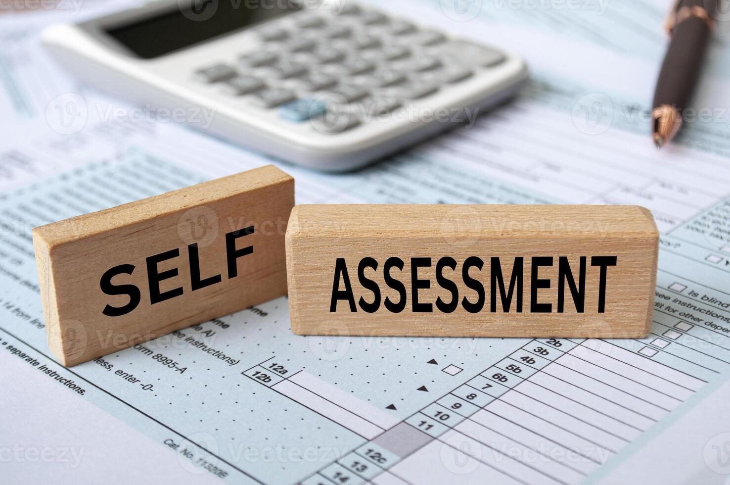 Self assessment text on wooden blocks with tax form and calculator background. Taxation concept photo