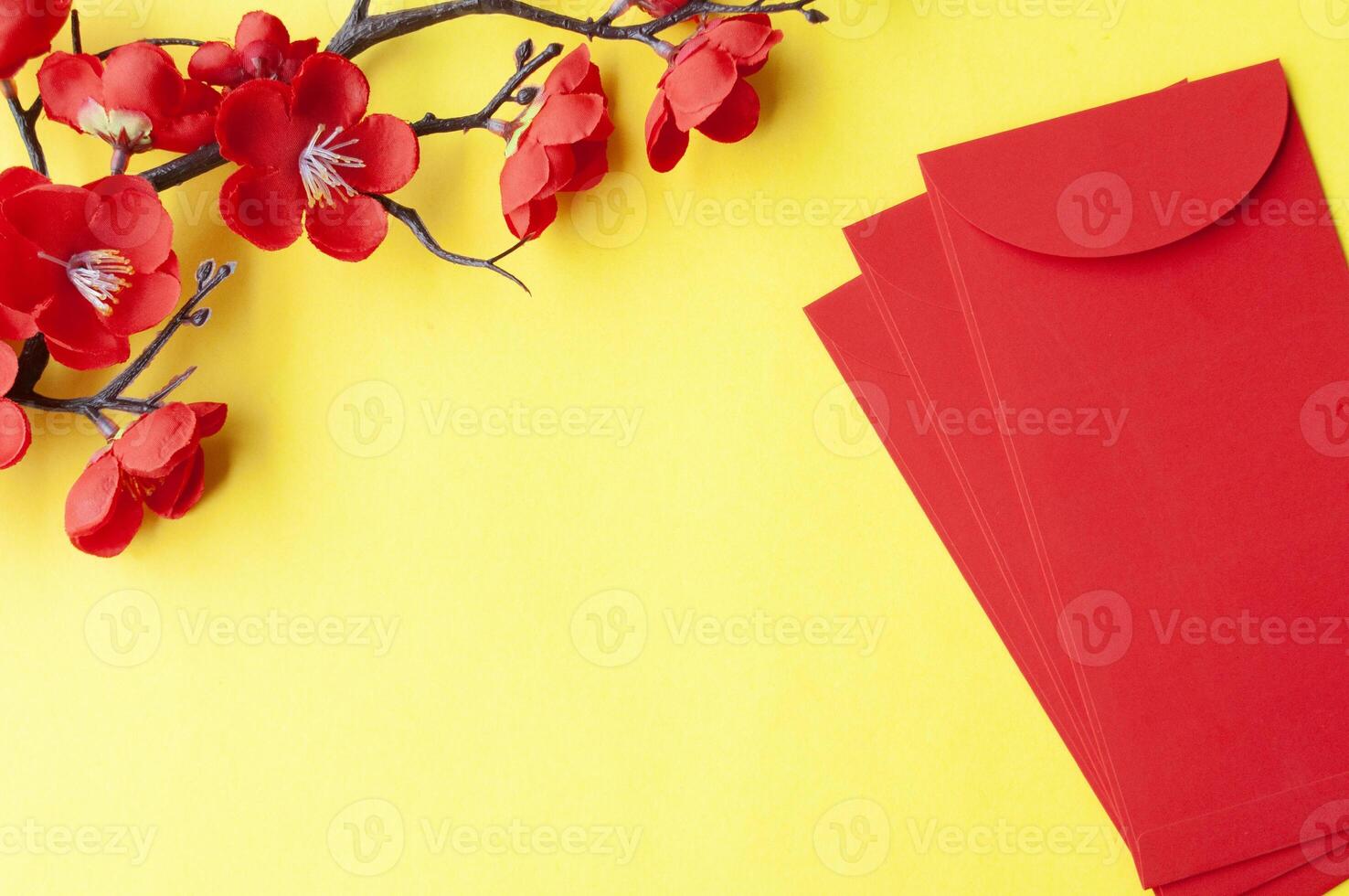 Top view of Chinese New Year red packet and cherry blossom with customizable space for text or wishes photo