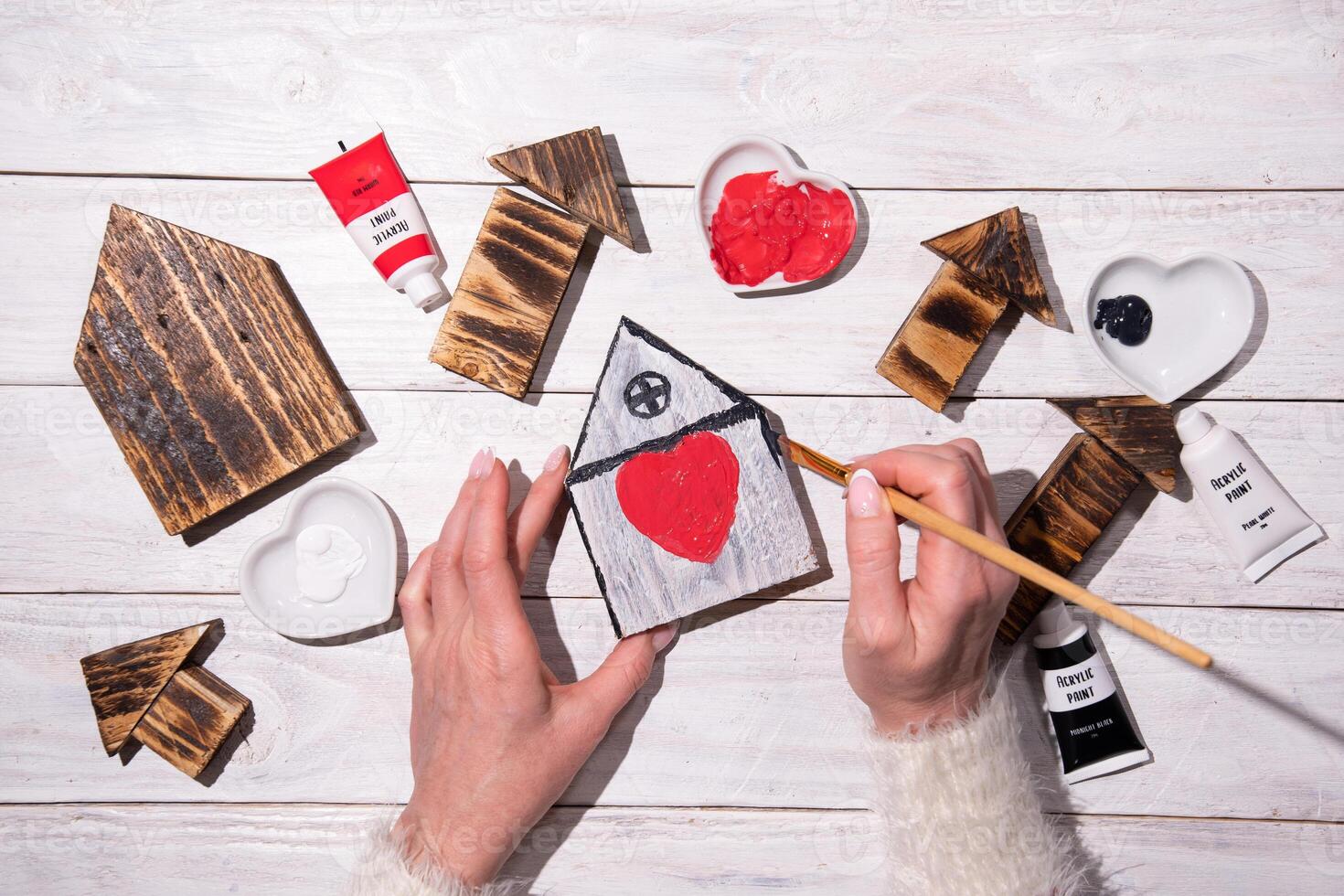 female hands draw a heart on a wooden house,step by step diy,crafting Sweet Home photo