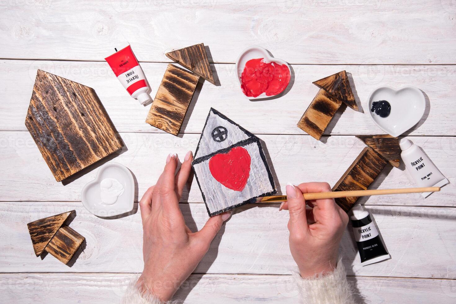 female hands draw a heart on a wooden house,step by step diy,crafting Sweet Home photo