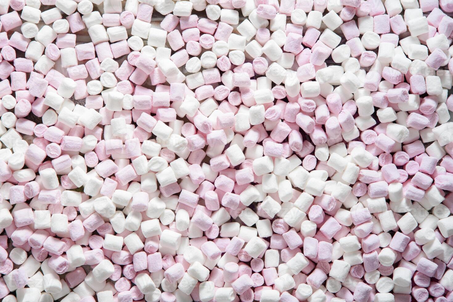 Pink and white mini puffy marshmallows background, closeup texture photo