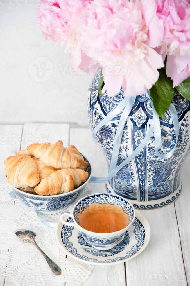 delicado primavera todavía vida con croissants y un ramo de flores de rosado peonías foto