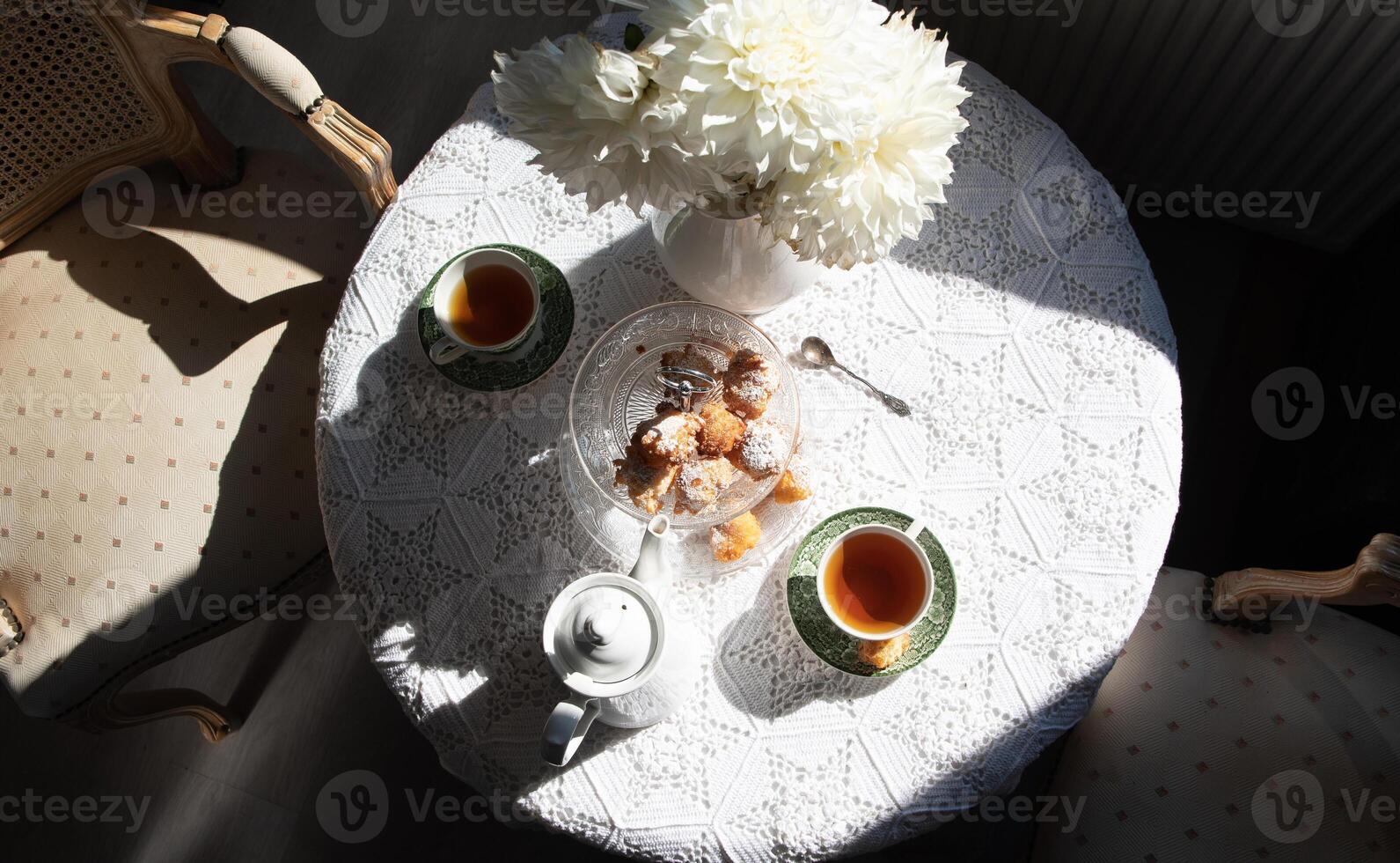 English style tea break, still life with flowers and donuts in the morning sun photo