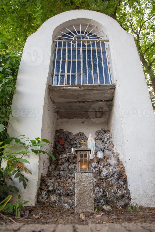 a chapel for prayers in the middle of the forest a figurine of St. Mary photo