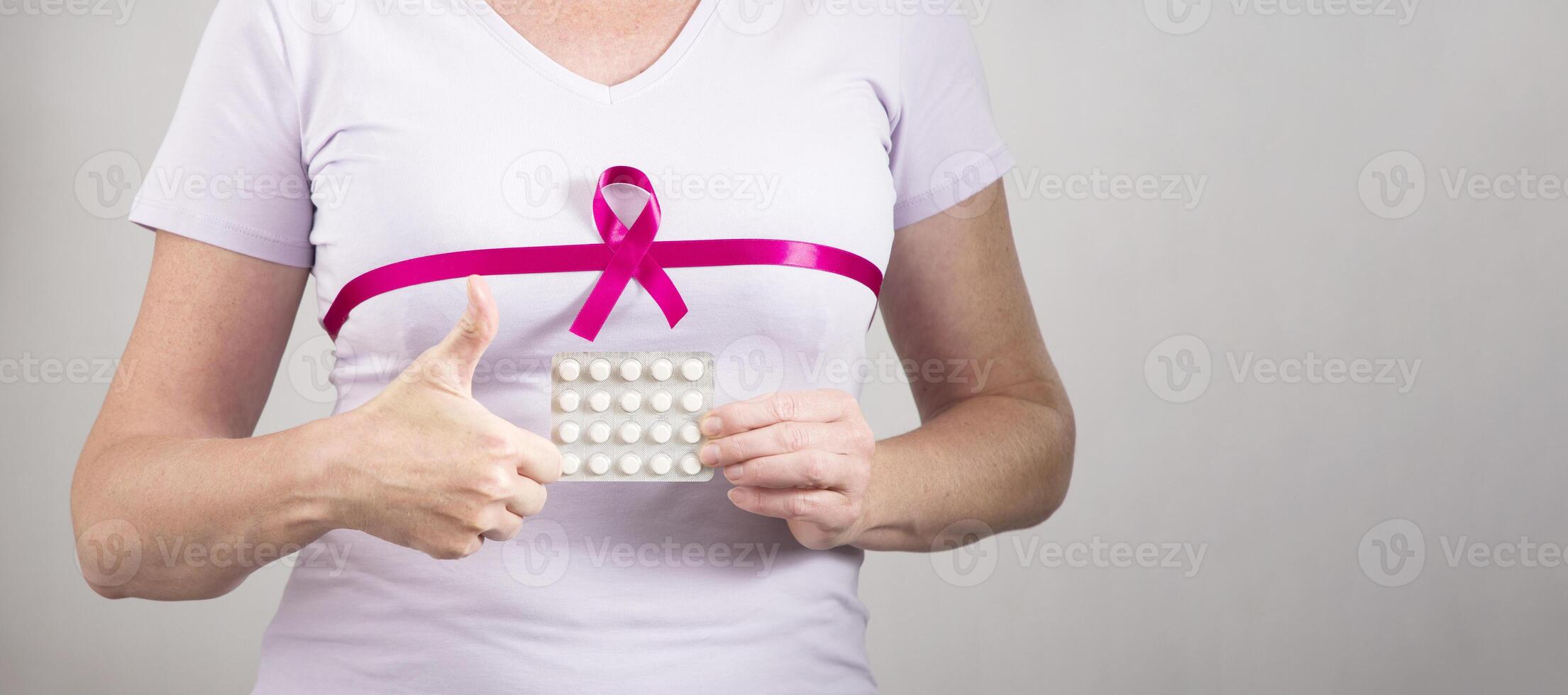 woman making heart sign with fingers on breast cancer protection symbol photo