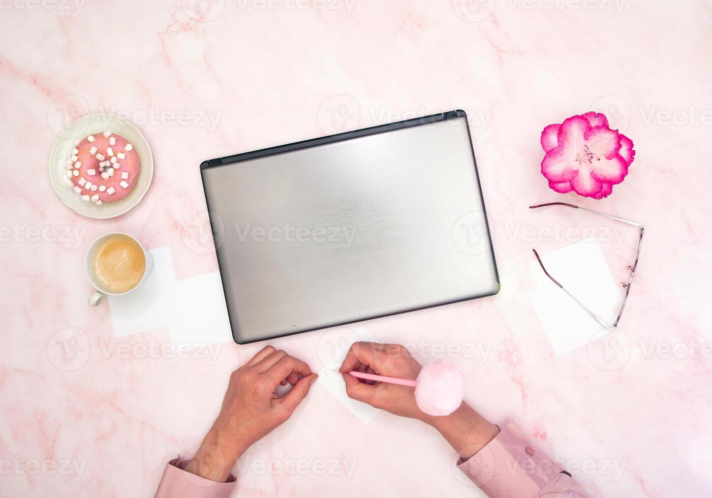 office worker in a pink shirt sits at a laptop, top view,next to a cup of coffee photo