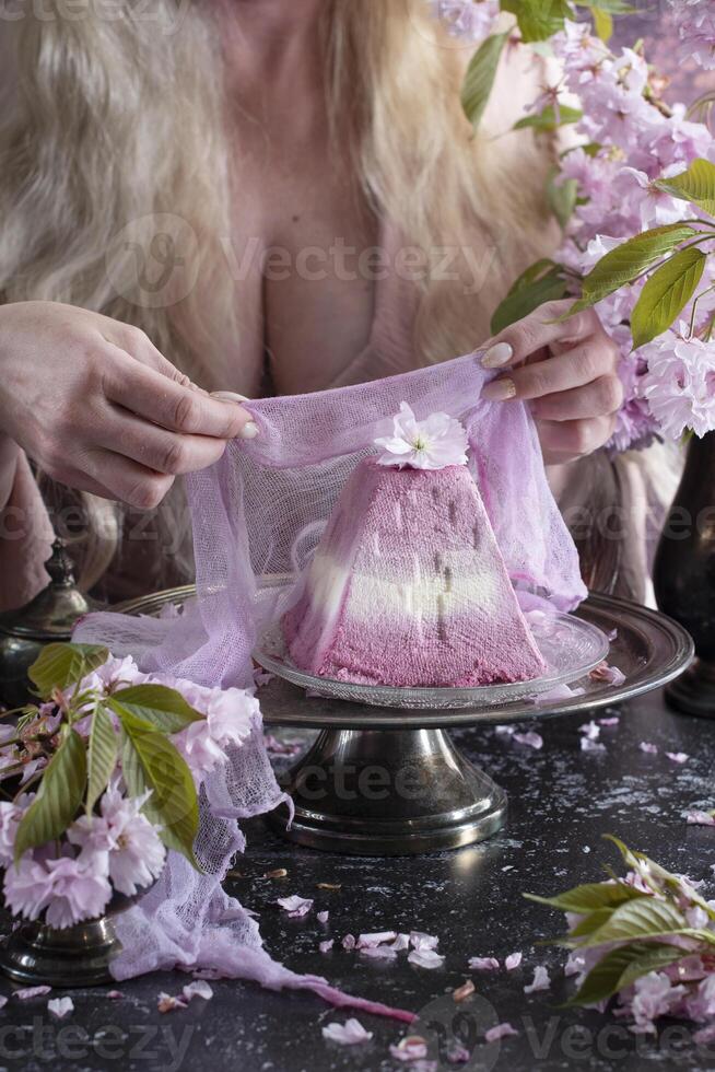 Traditional Easter Orthodox curd cake with sakura flowers, woman decorating food photo