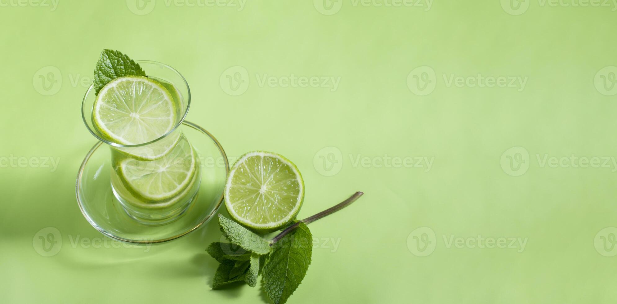 té con menta y Lima, con un calmante efecto, verde todavía vida de cerca en un verde fondo, parte superior vista. mojito, salud beber, alternativa medicina foto