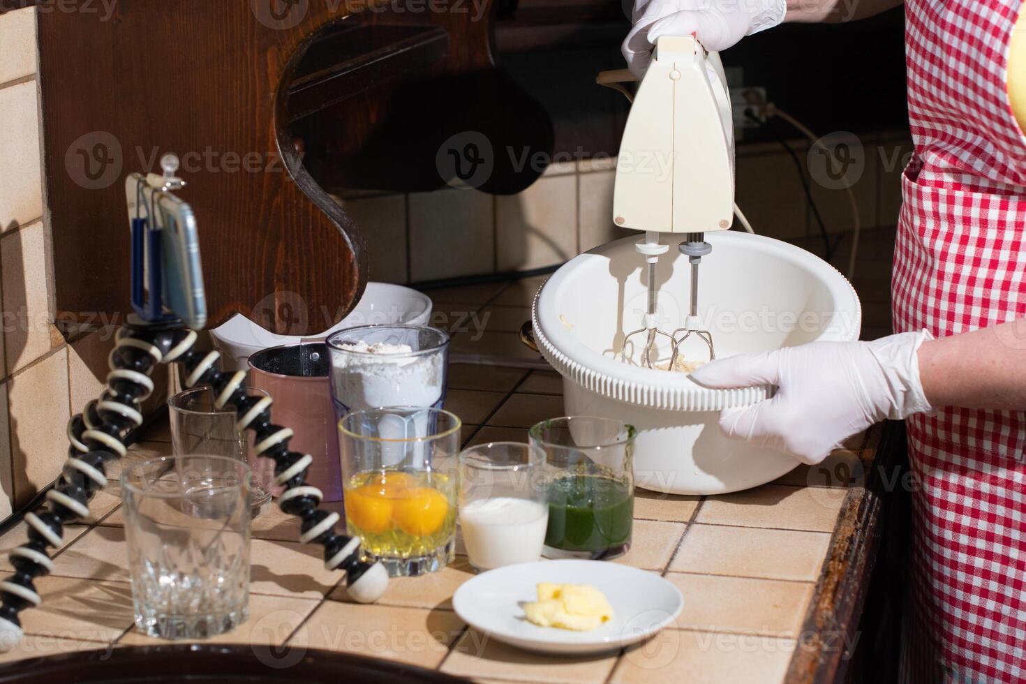 woman cooking spinach muffin step by step, kneading ingredients with mixer photo