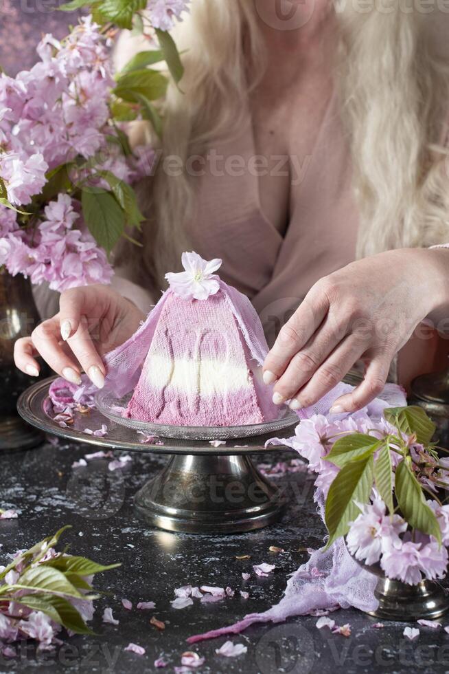 Traditional Easter Orthodox curd cake with sakura flowers, woman decorating food photo