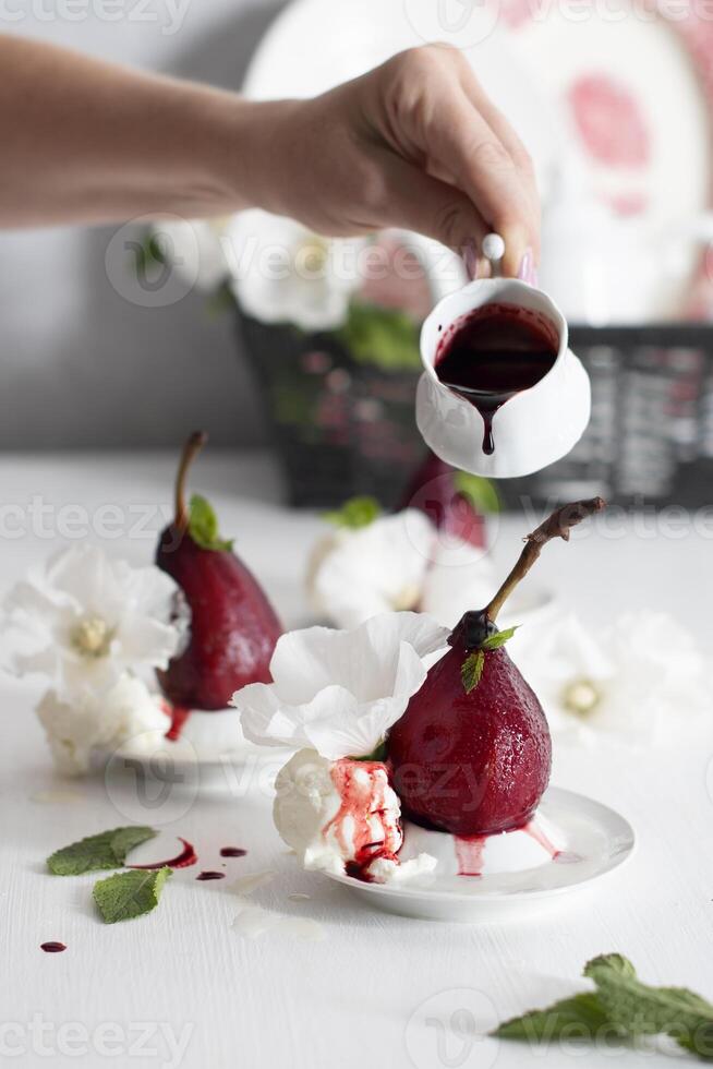 spicy pears cooked in red wine with vanilla ice cream on white dishes,delicious photo