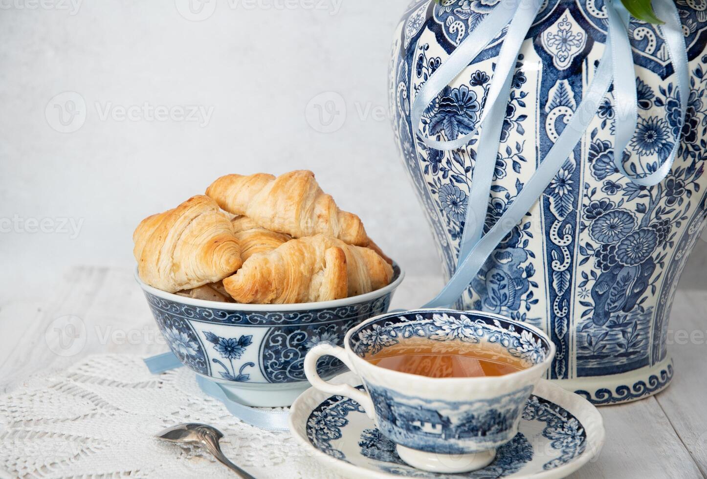 delicate spring still life with croissants and a bouquet of pink peonies photo