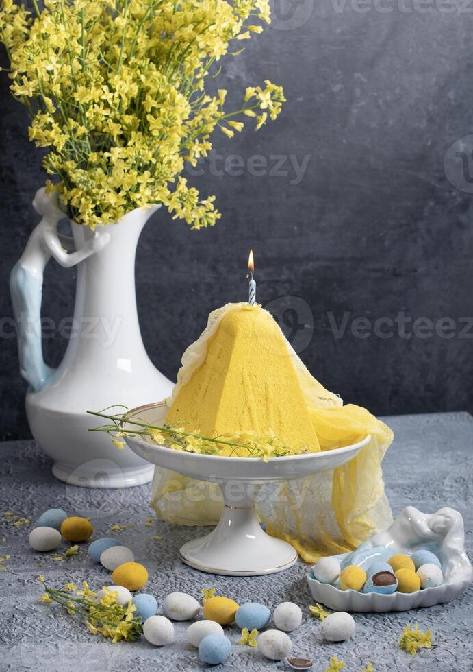 Traditional Easter Orthodox curd cake with yellow flowers on a grey table photo