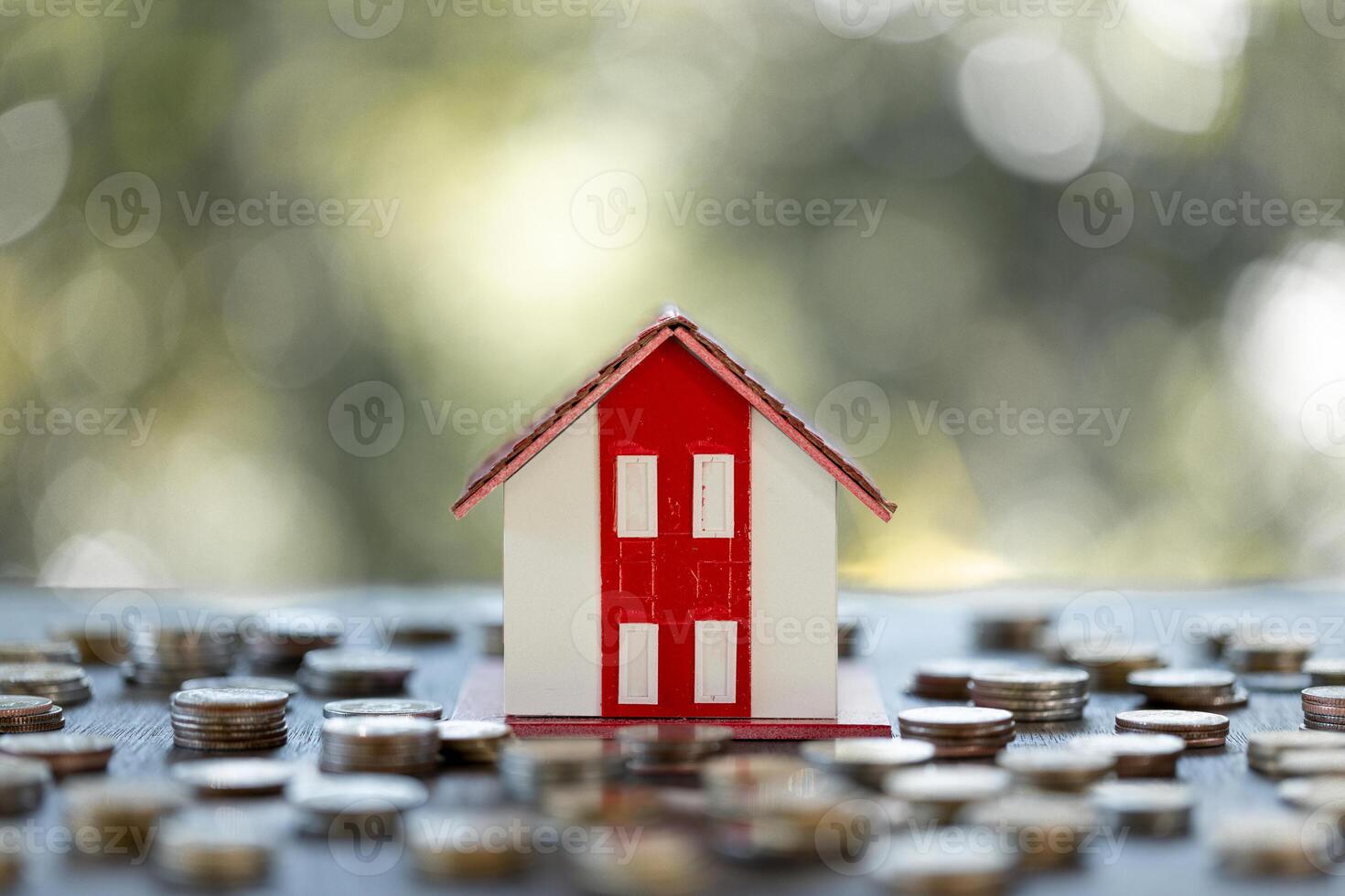 Model of house with coins on table on blurred background. Stack of growing coins, money saving or investing for home loan or real estate. Investment property, Saving money for retirement concept. photo