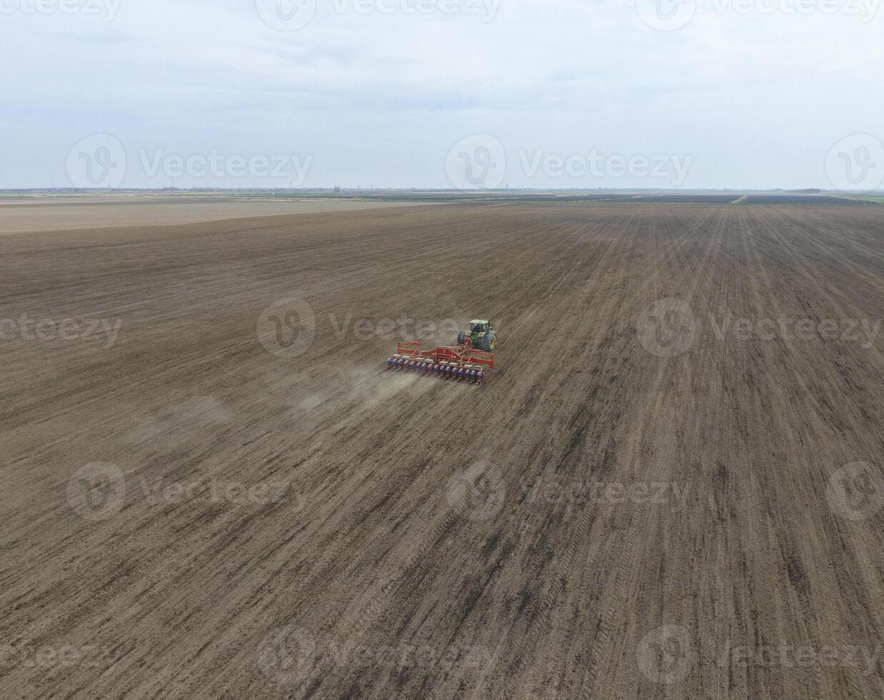 siembra de maíz. tractor con un sembradora en el campo. utilizando un sembradora para plantando maíz. foto