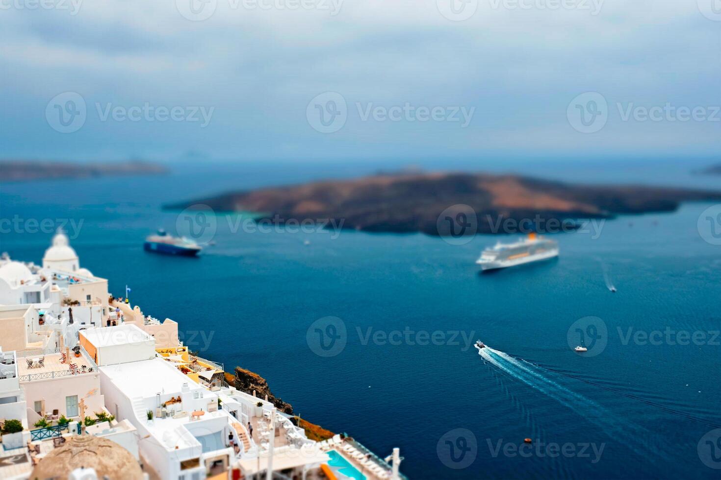 View of Fira town on Santorini island with cruise ships in sea photo